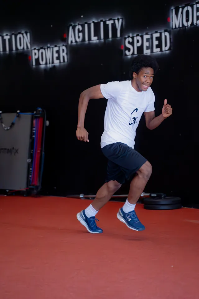 Athlete smiling mid-drill in front of the Power, Agility, Speed wall