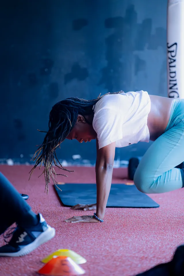 Woman working through a mobility stretch on the turf