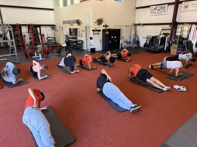 High school team doing side planks together during a team training session